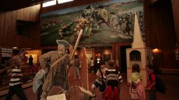 Children in the visitor center lobby exploring Revolutionary War-related exhibits